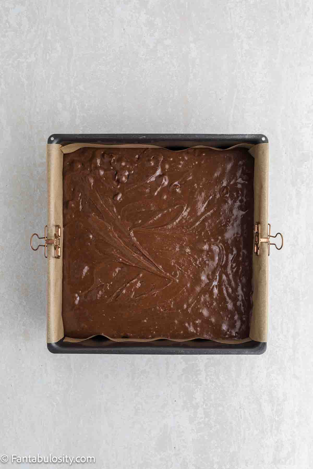Condensed brownie batter poured in to square baking pan.