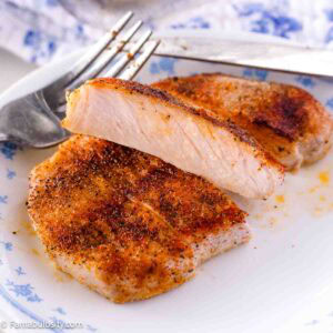 A sliced, boneless pork chop that was baked in the oven, sitting on a plate.