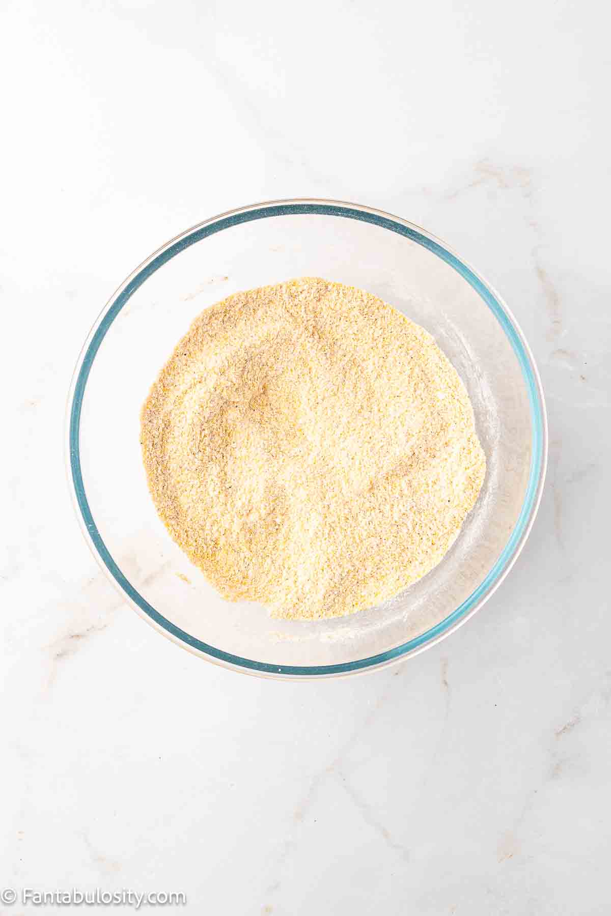 Cornmeal, flour and seasonings mixed together in a mixing bowl.