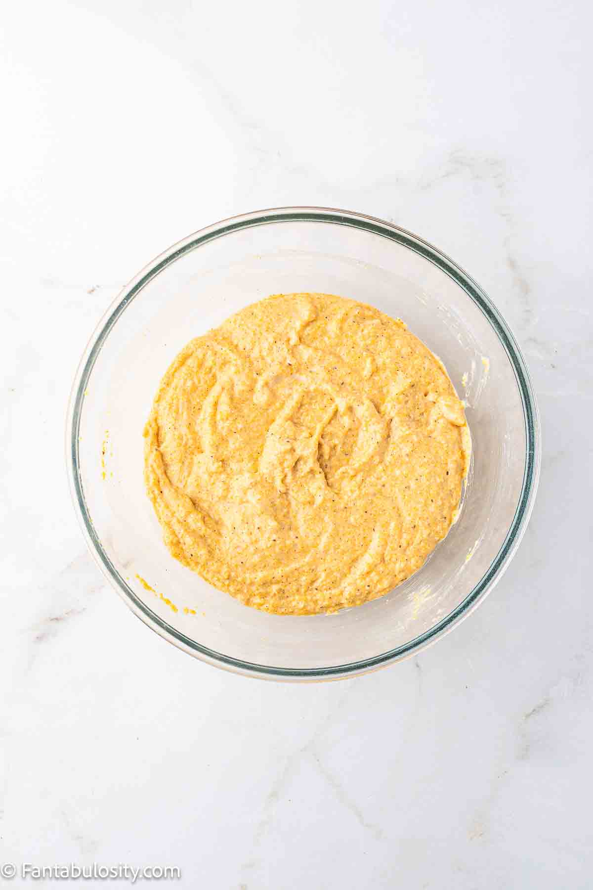 Wet ingredients added to dry ingredients in mixing bowl.
