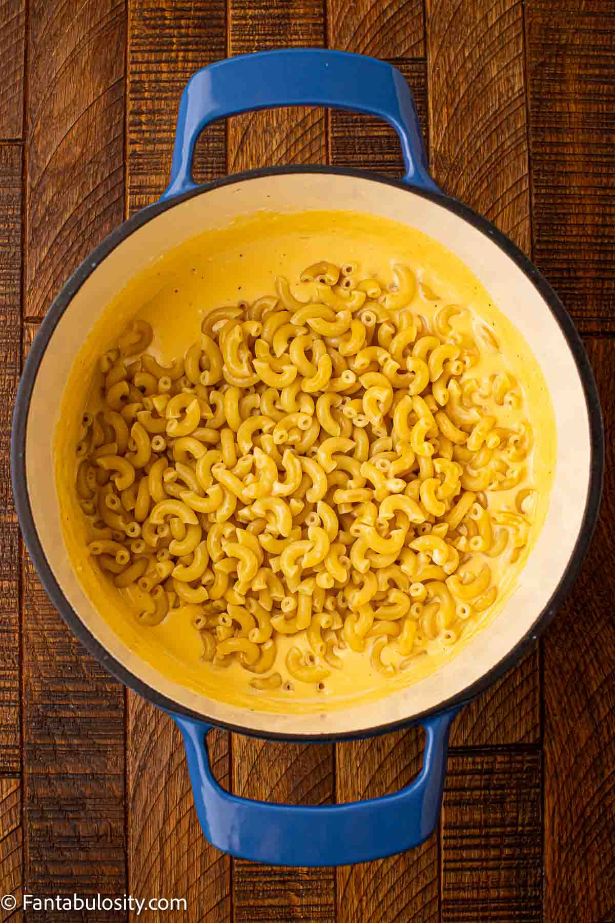 Cooked macaroni added to cheese and cream mixture.