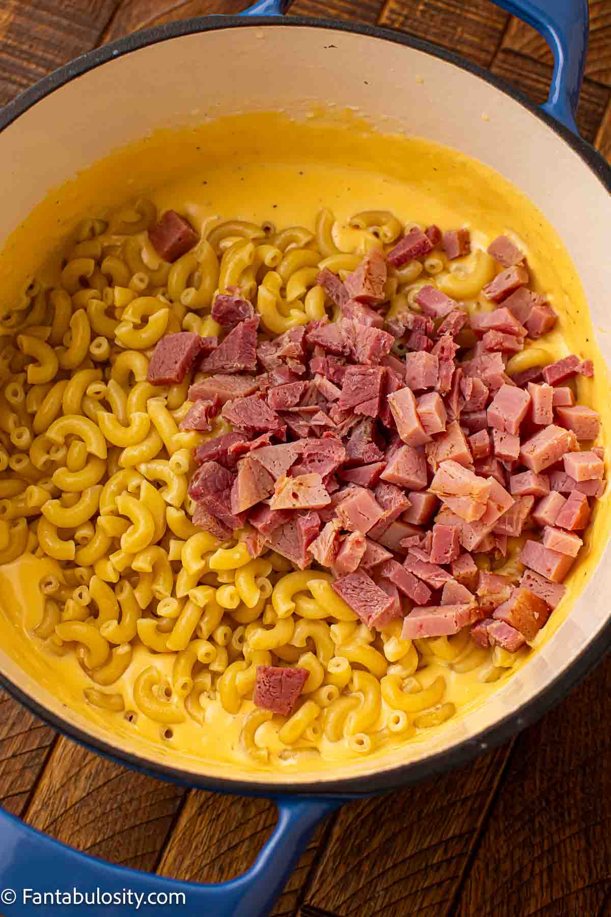 Ham added to dutch oven with cheese and macaroni.