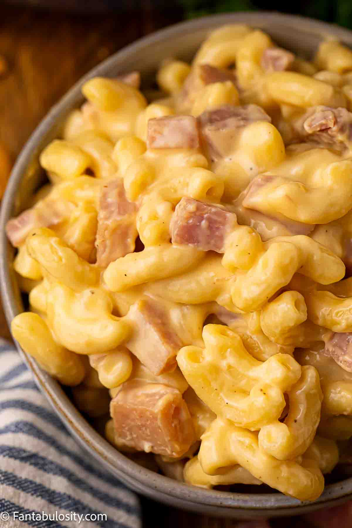 A single serving of mac and cheese with ham.