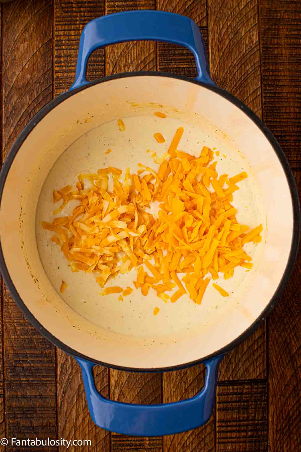 Shredded cheese added to milk and cream mixture.