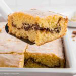 A square slice of sock it to me cake on a spatula.