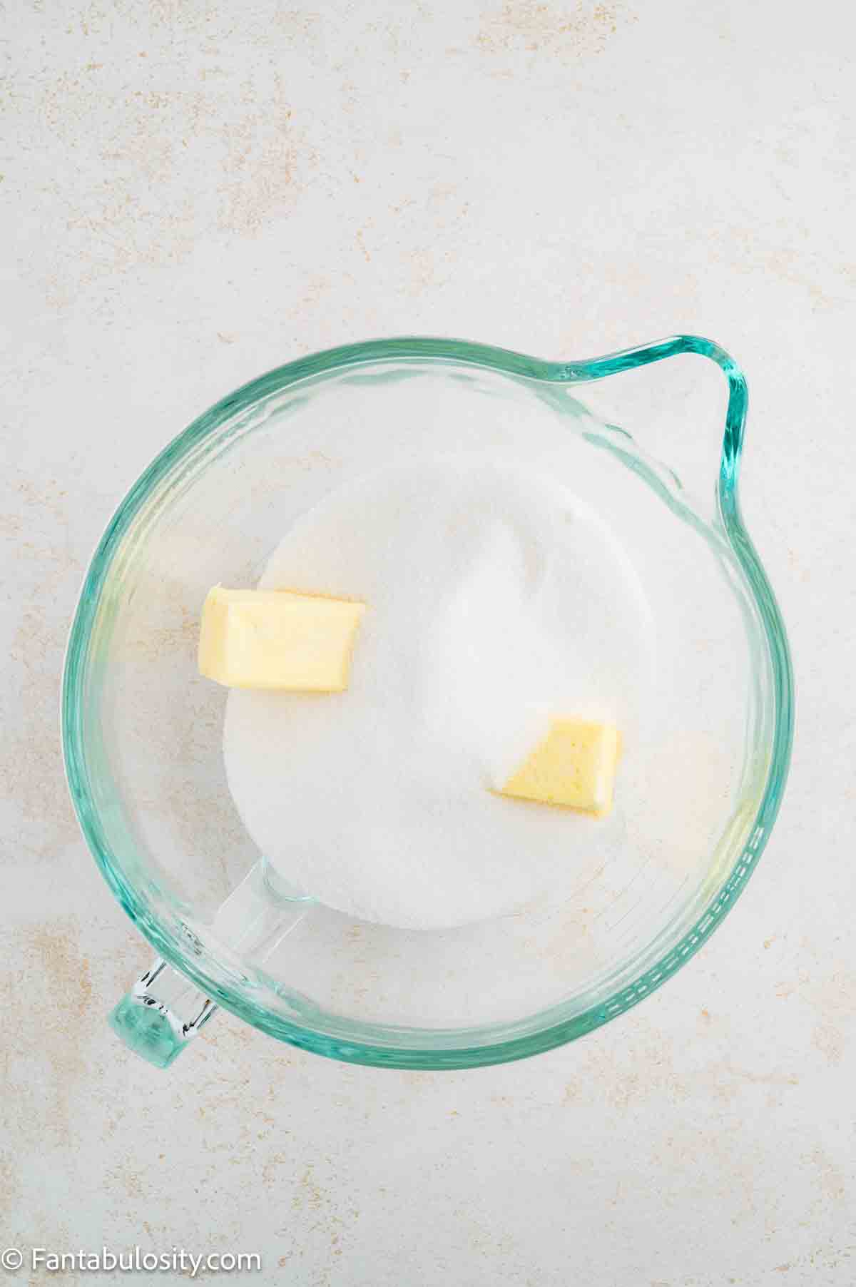 Butter and sugar in mixing bowl.