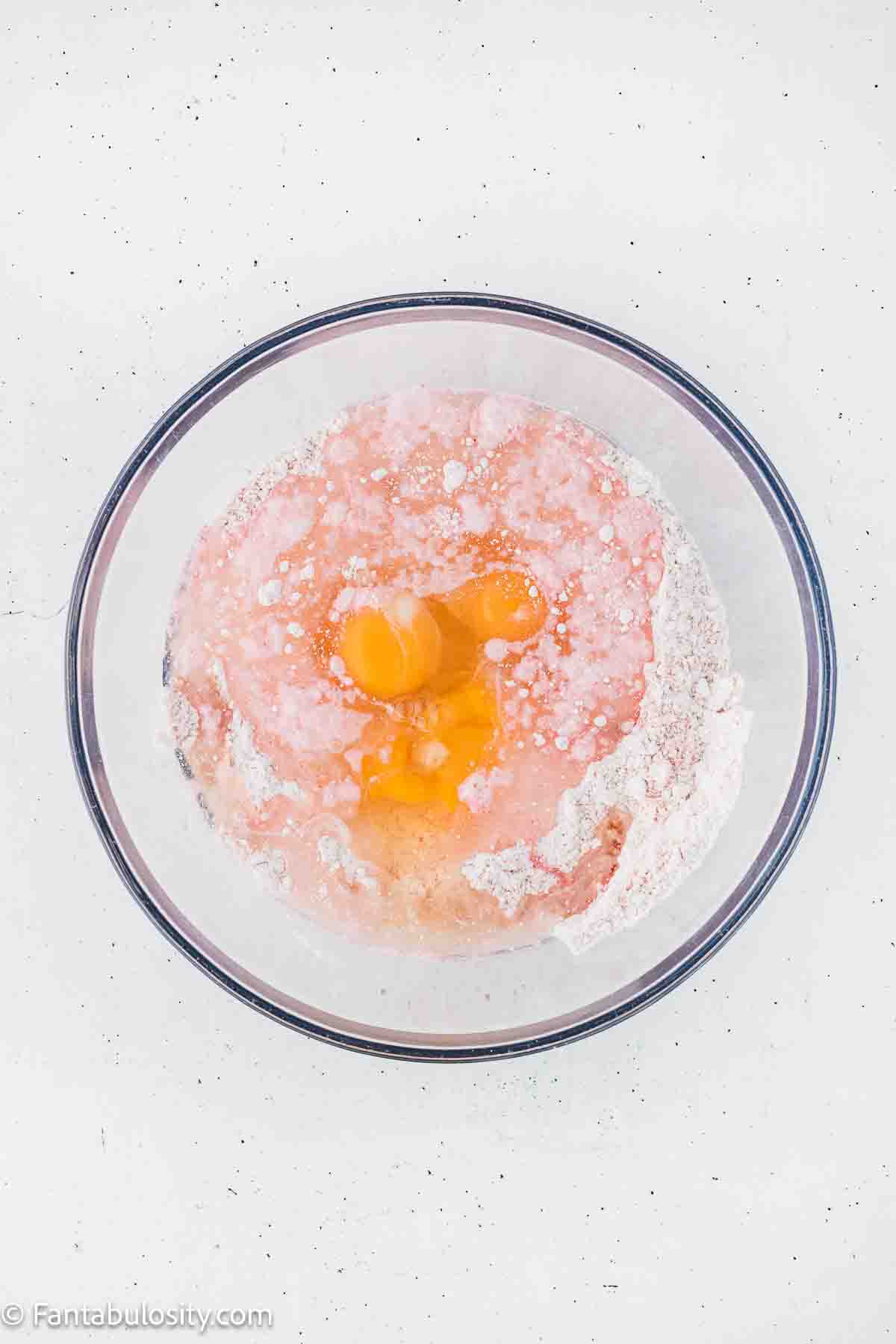 Oil and eggs added to cake mix in mixing bowl.