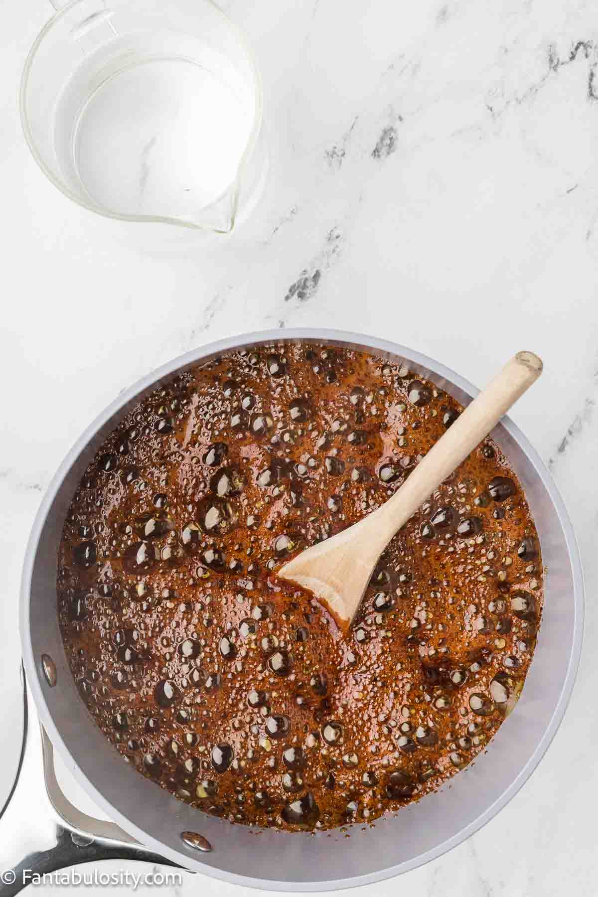 Sugar and water bubbling in saucepan.