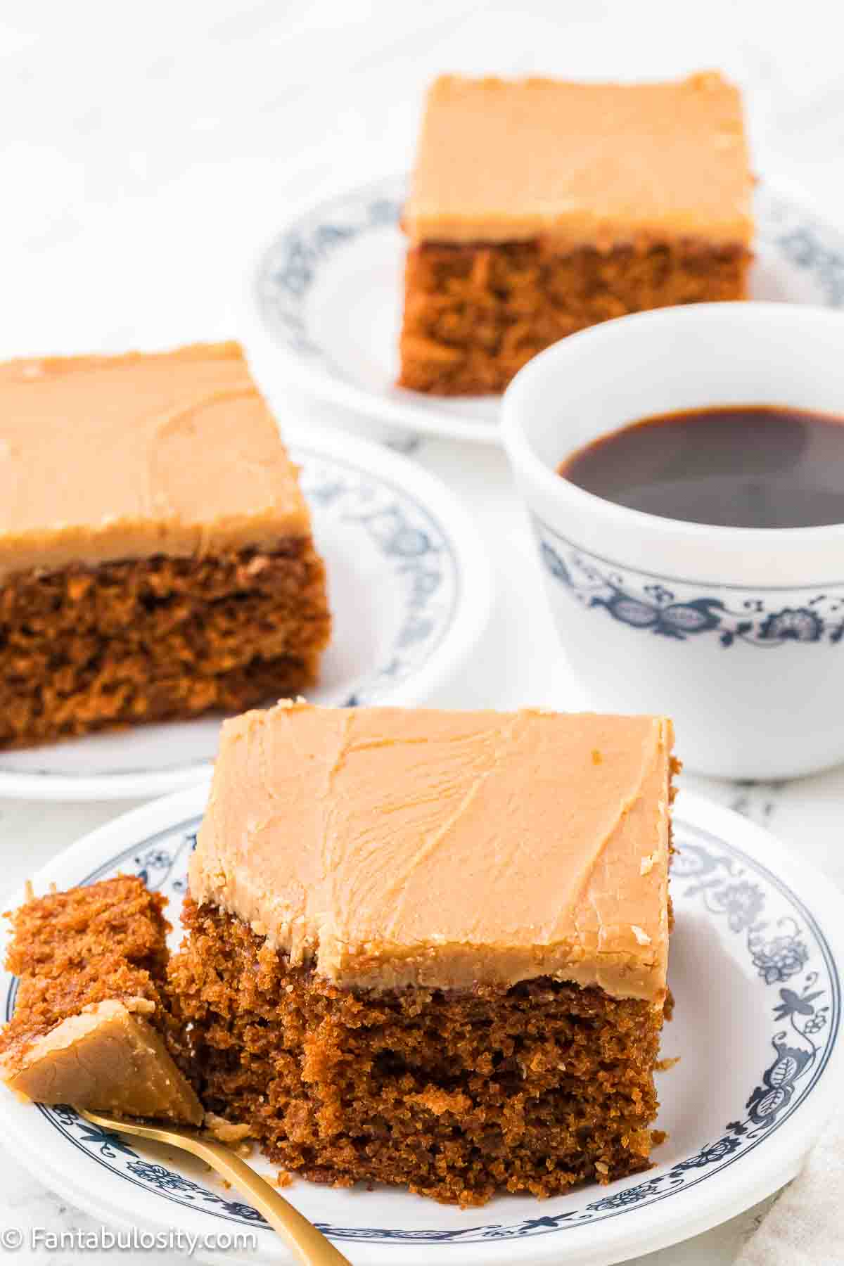 A slice of burnt sugar cake, sitting on a vintage plate, with a bite taken off.