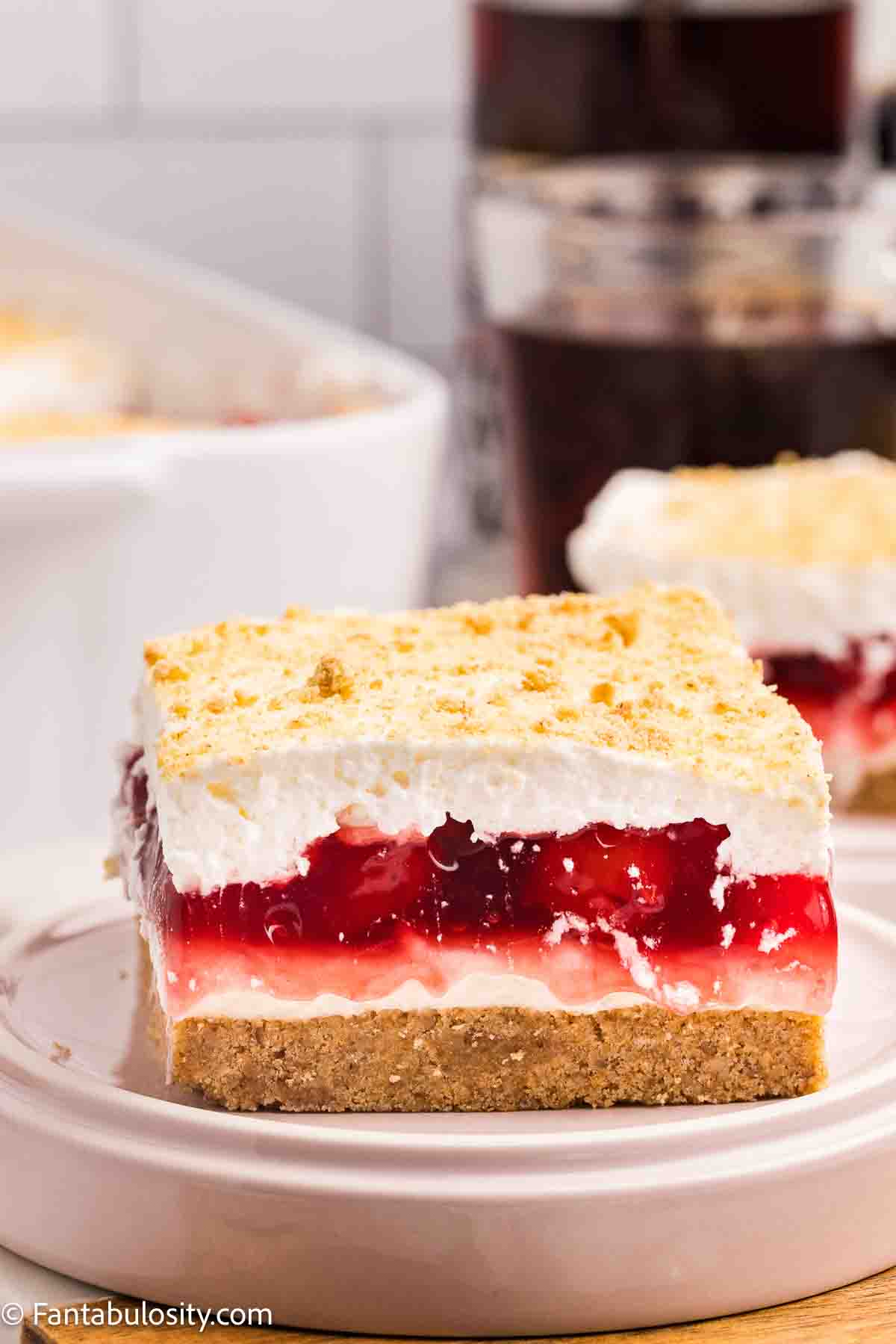 A slice of cherry yum yum on a round plate.