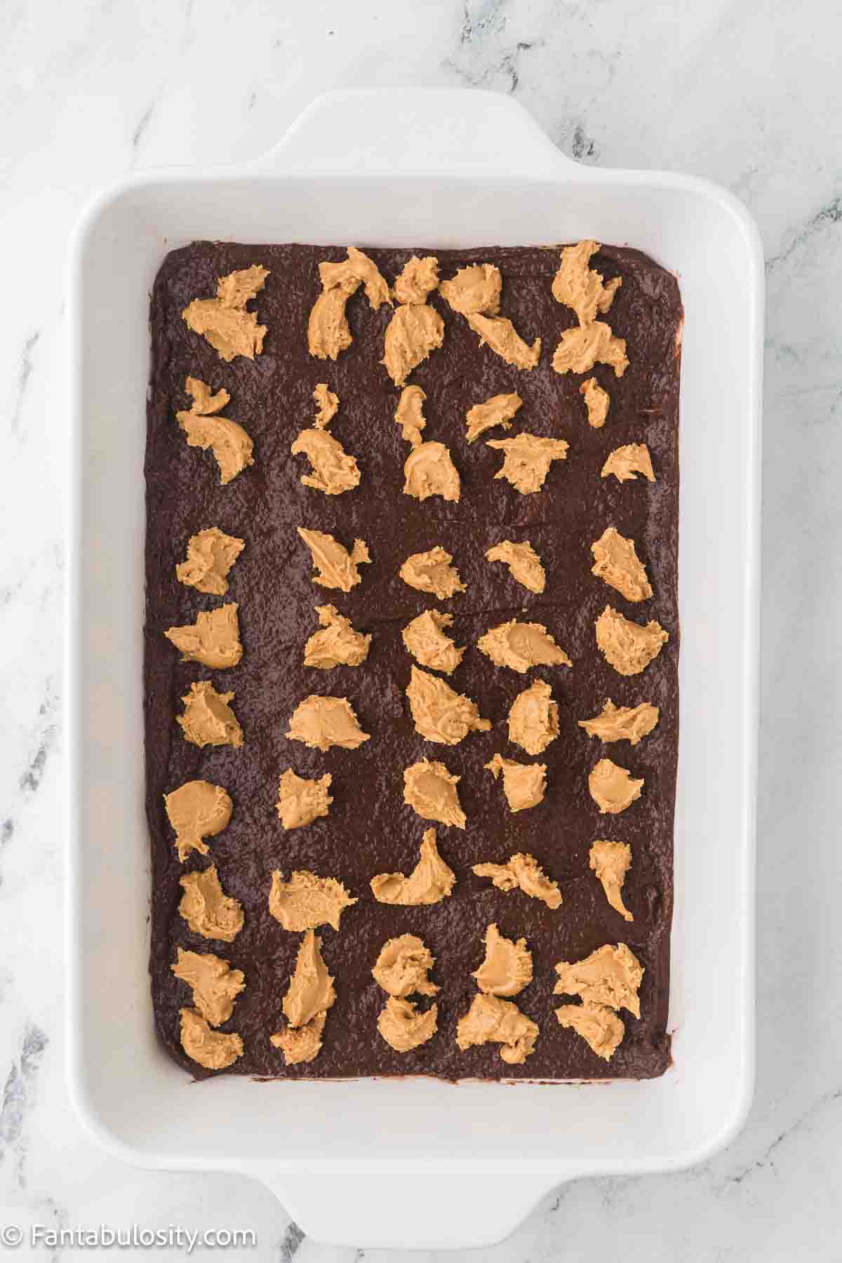 Peanut butter dollops on top of chocolate pudding.