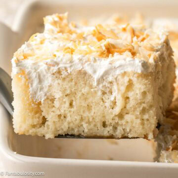 A slice of coconut poke cake on a spatula.