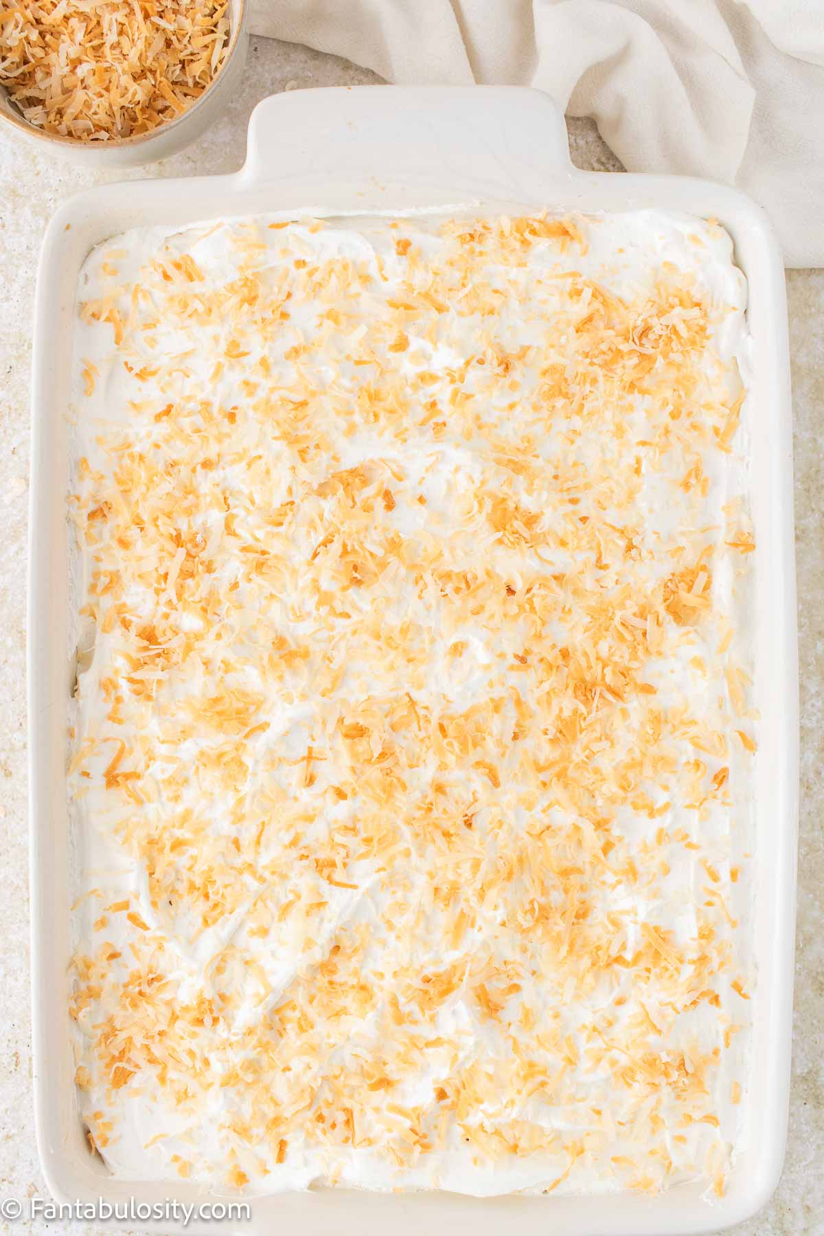 Toasted coconut on coconut poke cake.