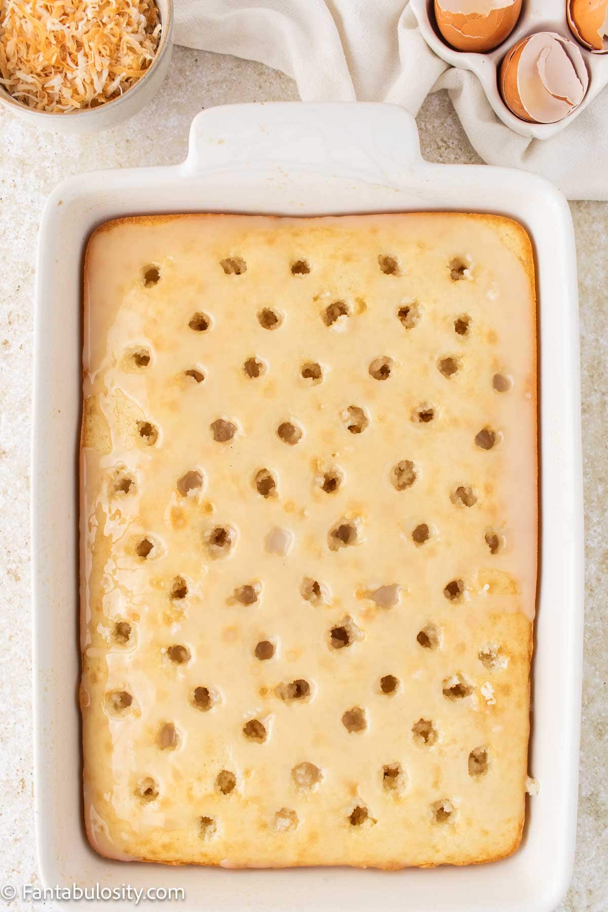 Cream of coconut and sweetened condensed milk poured over baked cake.