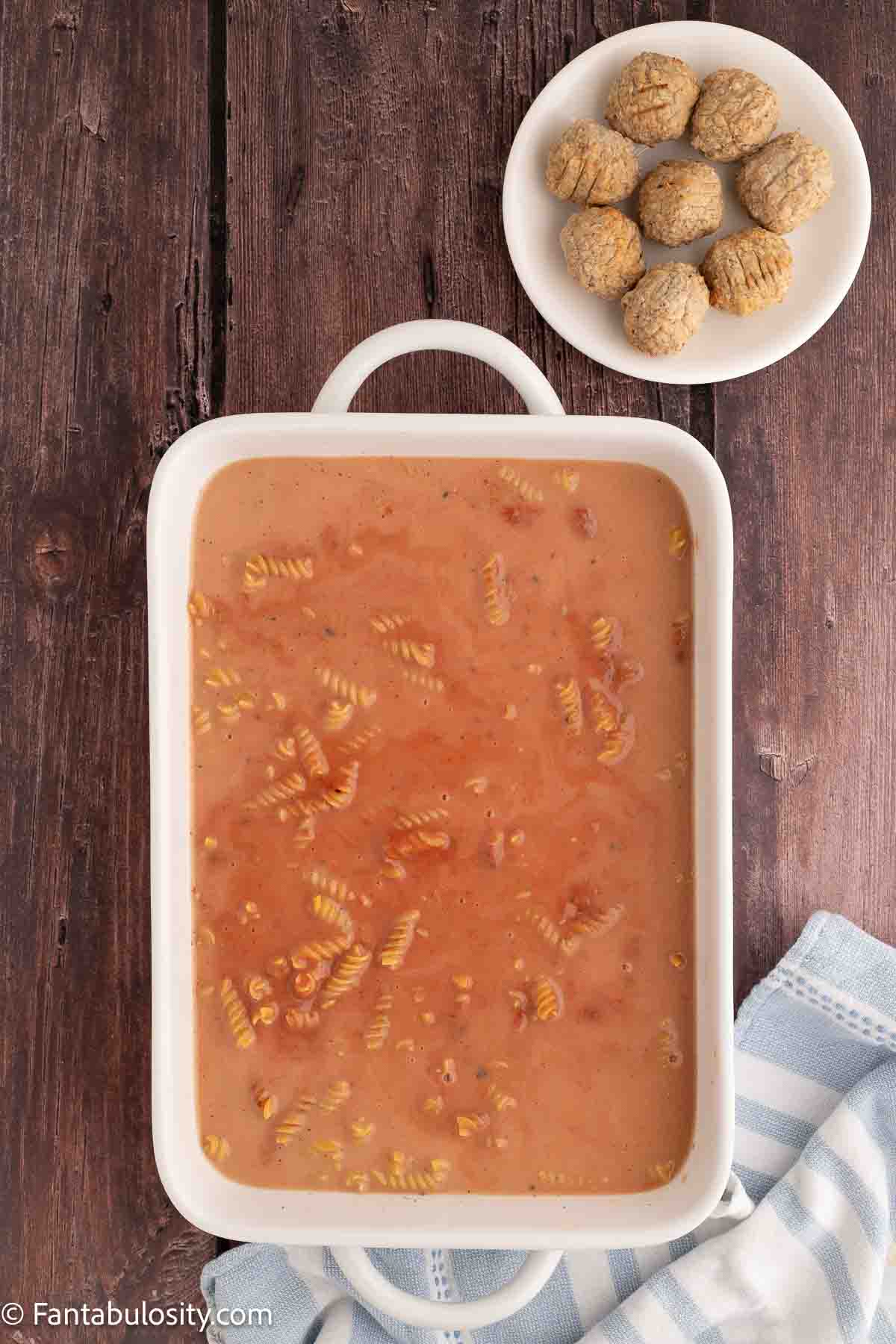 Noodles, broth, and sauce in baking dish.