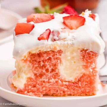 A slice of strawberry cheesecake poke cake on a round plate.
