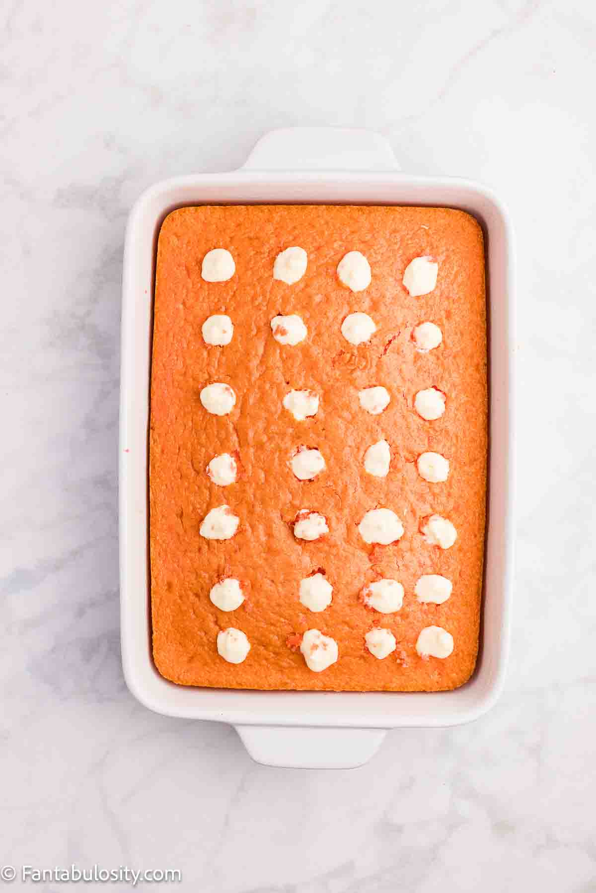 Holes in cake filled with pudding and cream cheese mixture.