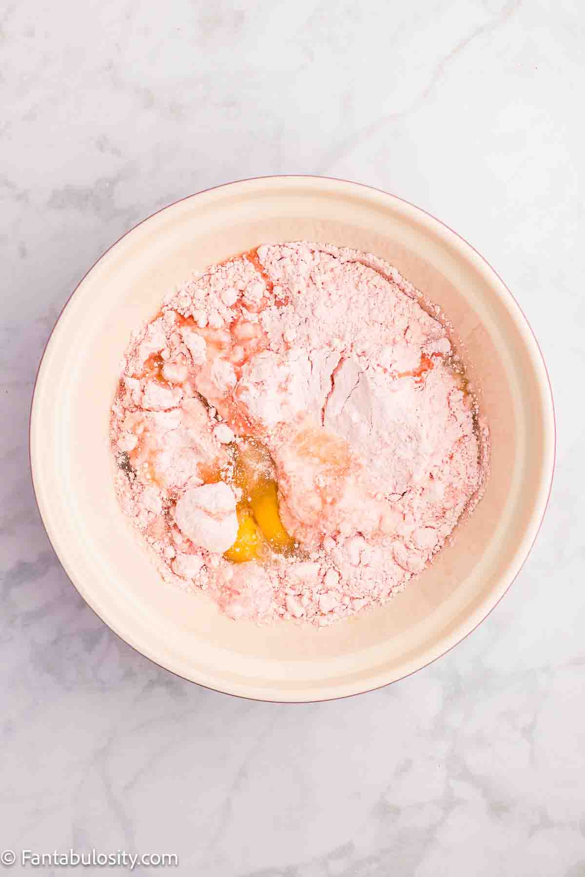 Strawberry cake mix, eggs and oil in a mixing bowl.