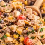 Cowboy Pasta Salad in bowl with wooden spoon.