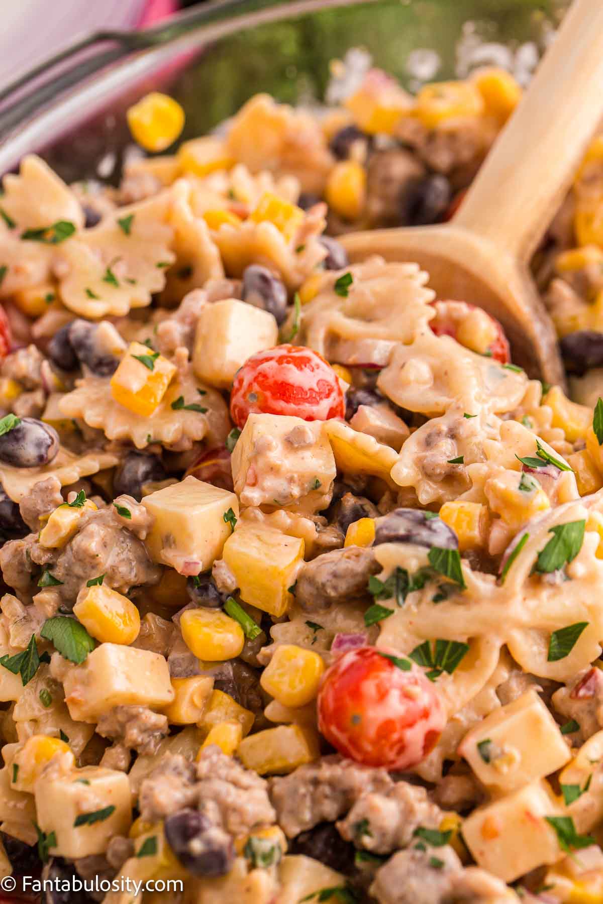Cowboy pasta in bowl with wooden spoon.