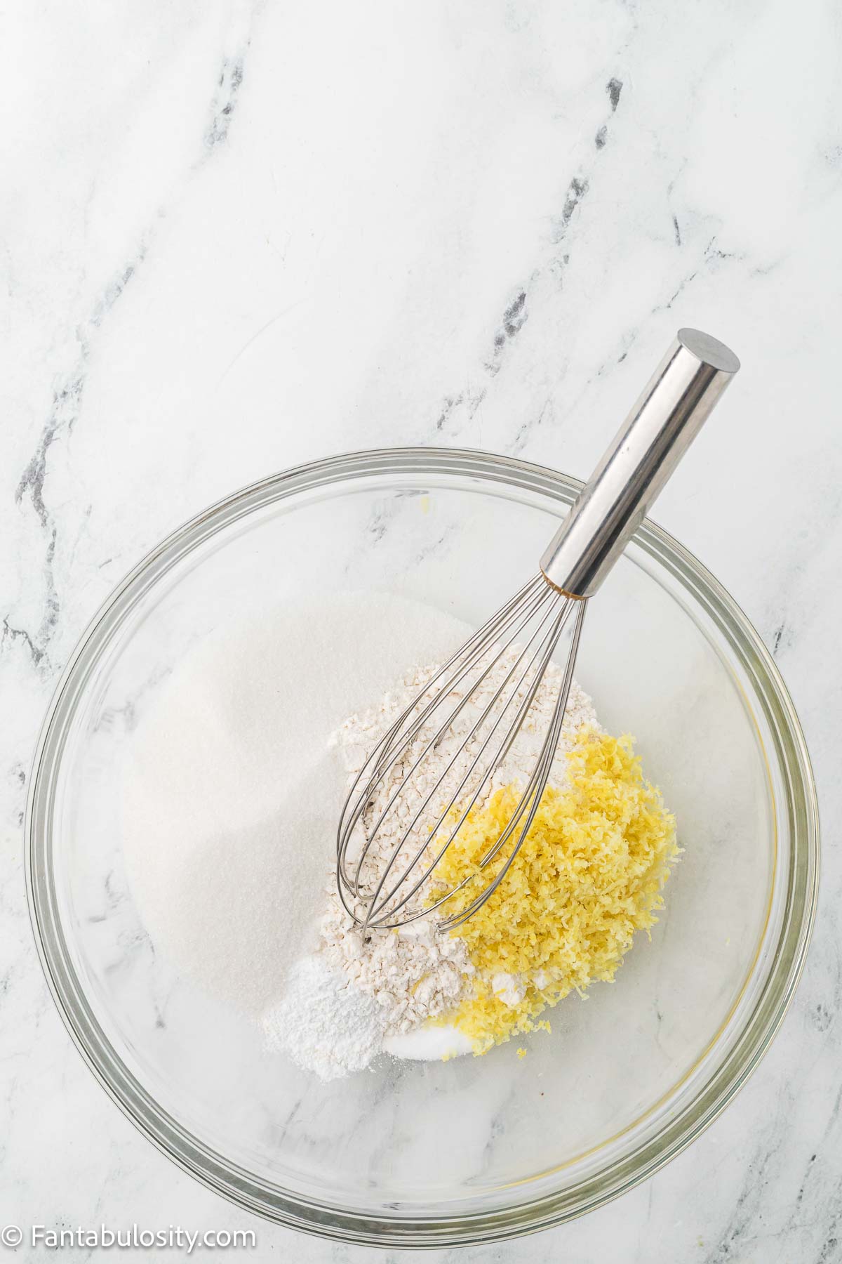 Dry ingredients and lemon zest in mixing bowl with whisk.
