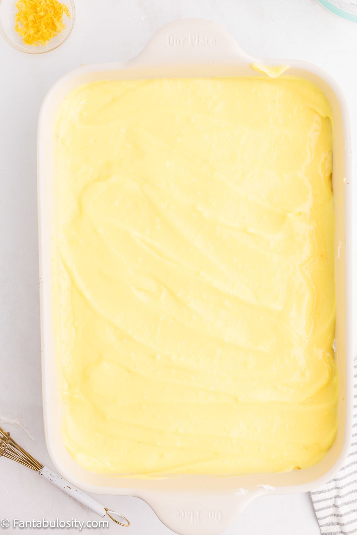 Lemon pudding mix layered on top of cream cheese mixture in pan.