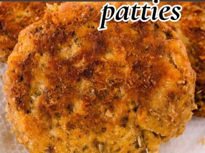 Old fashioned fried salmon patties sitting on vintage plate.