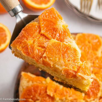 Orange upside down cake sliced on spatula.