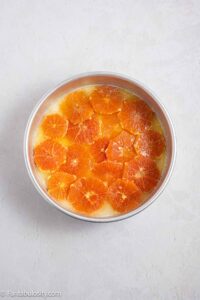 Oranges and sugar in bottom of round cake pan.