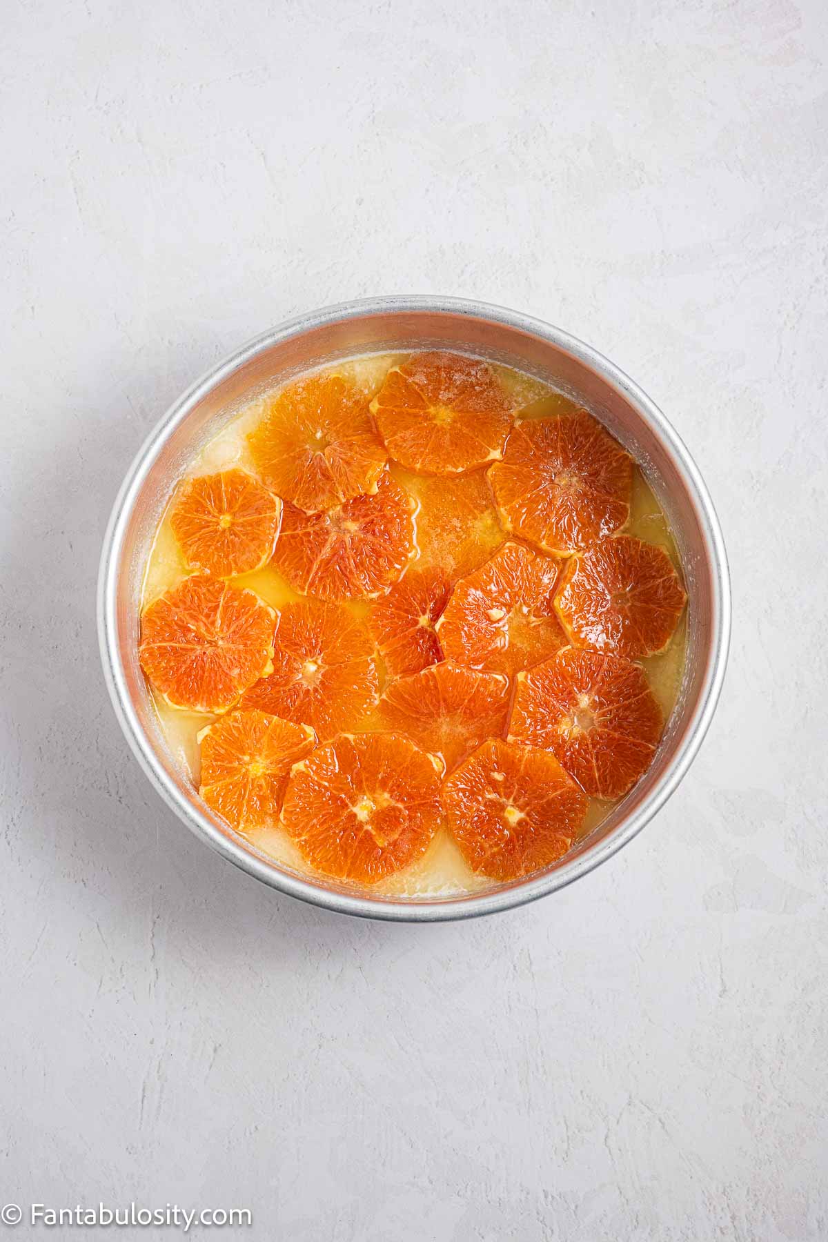 Oranges, butter and sugar in bottom of cake pan.