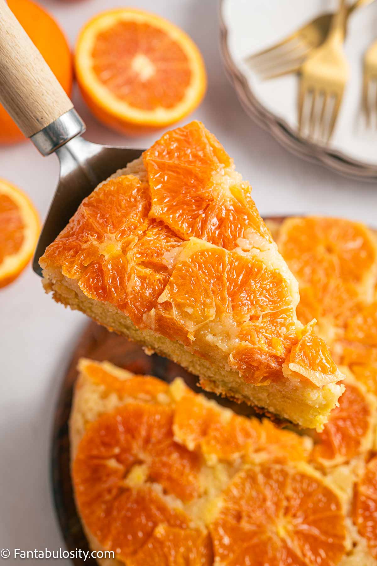 A spatula holding a piece of orange upside down cake.