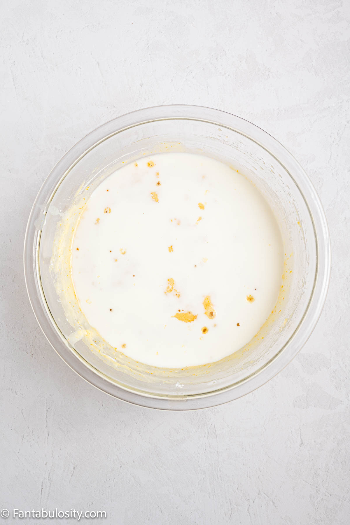 Milk added to orange cake batter.