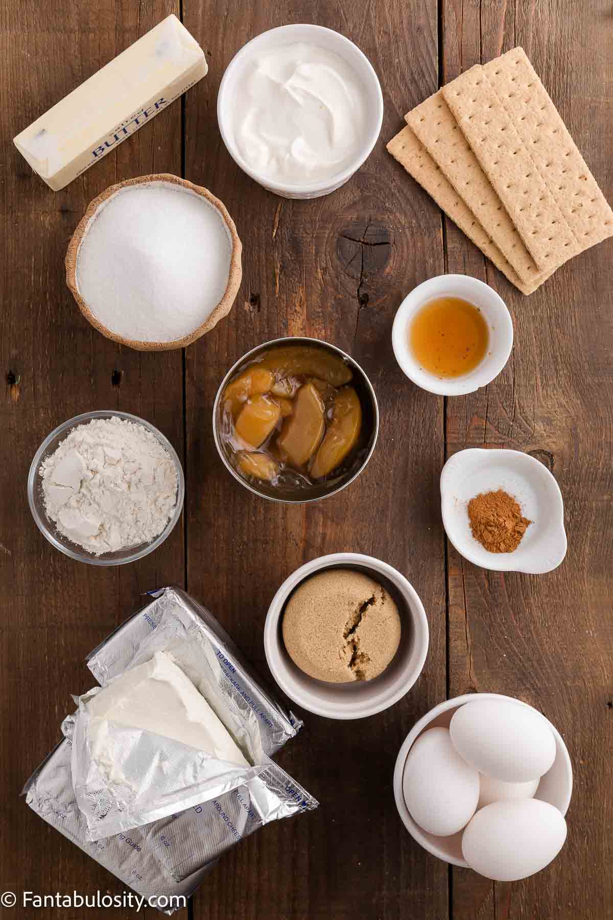 Ingredients to make peach cobbler cheesecake on wooden table