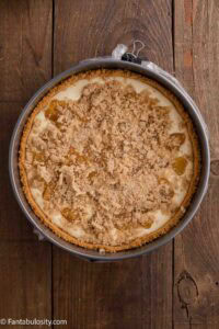 Half of the cheesecake batter poured in to baked crust, topped with peach mixture and topping.