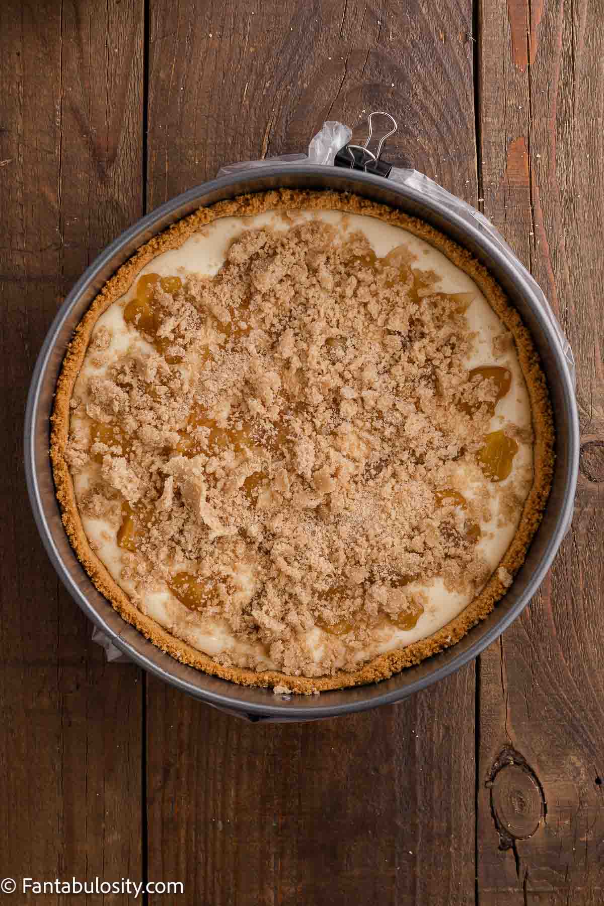 Half of the cheesecake batter poured in to baked crust, topped with peach mixture and topping.