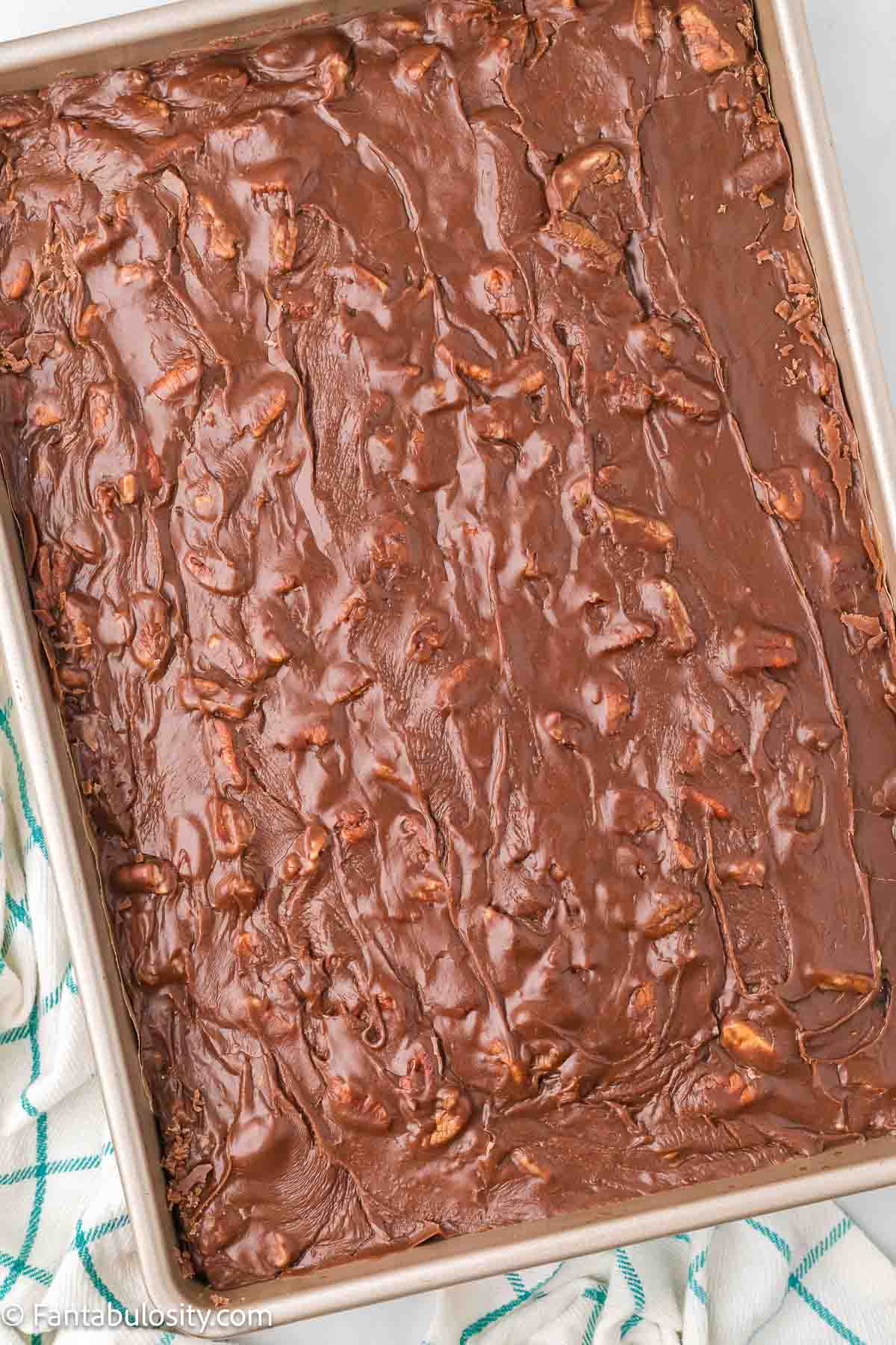 Nutty, chocolate stove-top icing poured and spread on top of chocolate Westhaven cake.