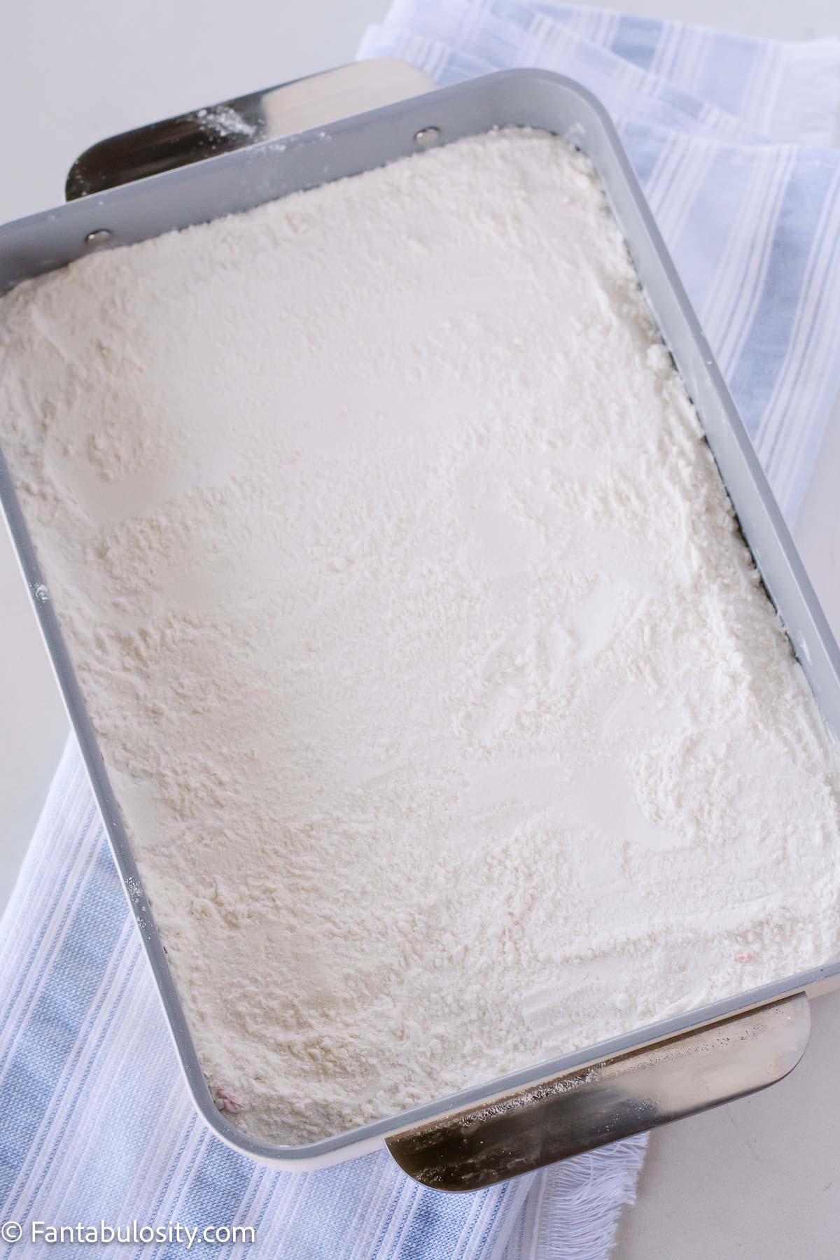 Yellow cake mix sprinkled and spread on as an even layer on top of pie filling.