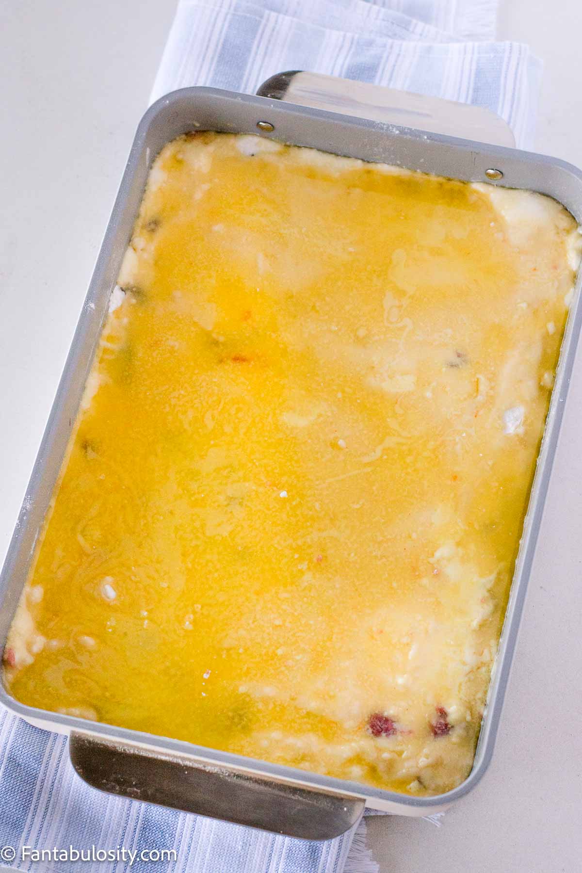 Melted butter poured on top of cake mix for dump cake.