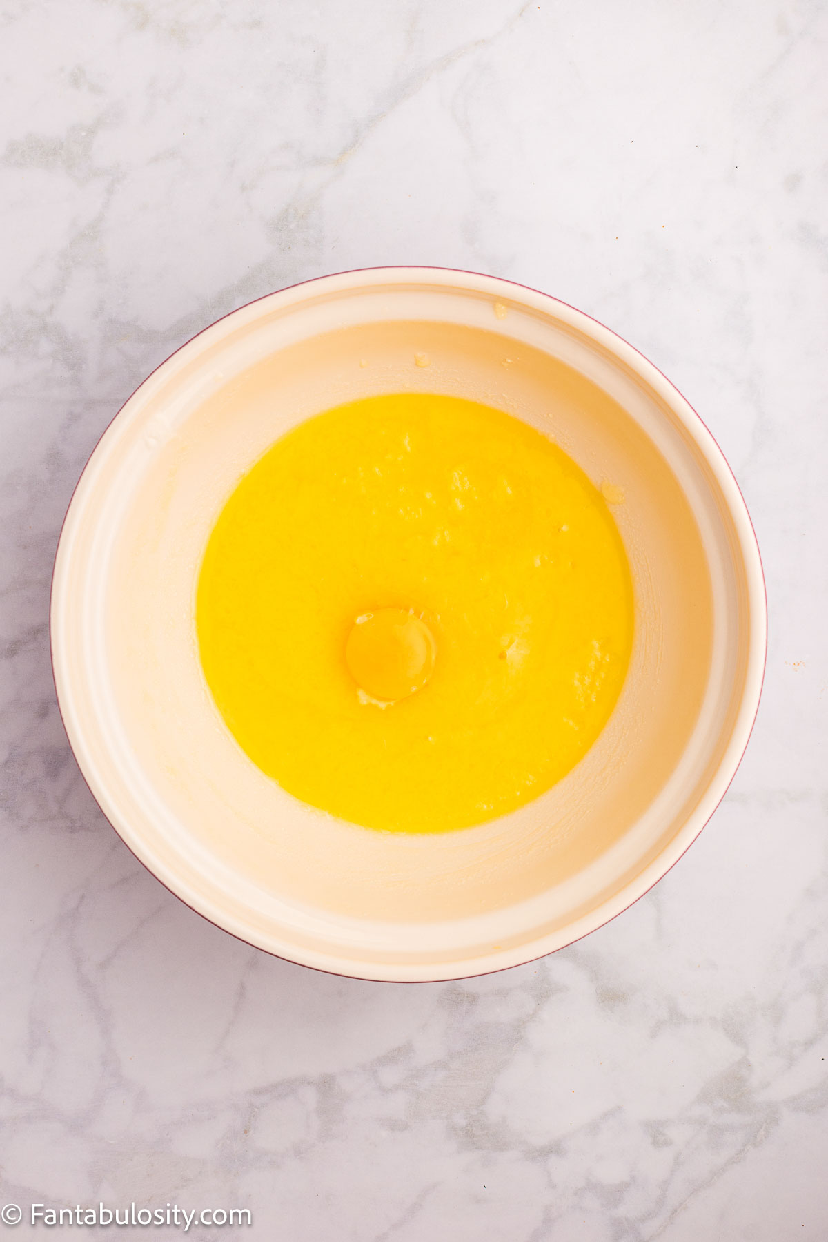 Eggs added to butter and sugar in mixing bowl.