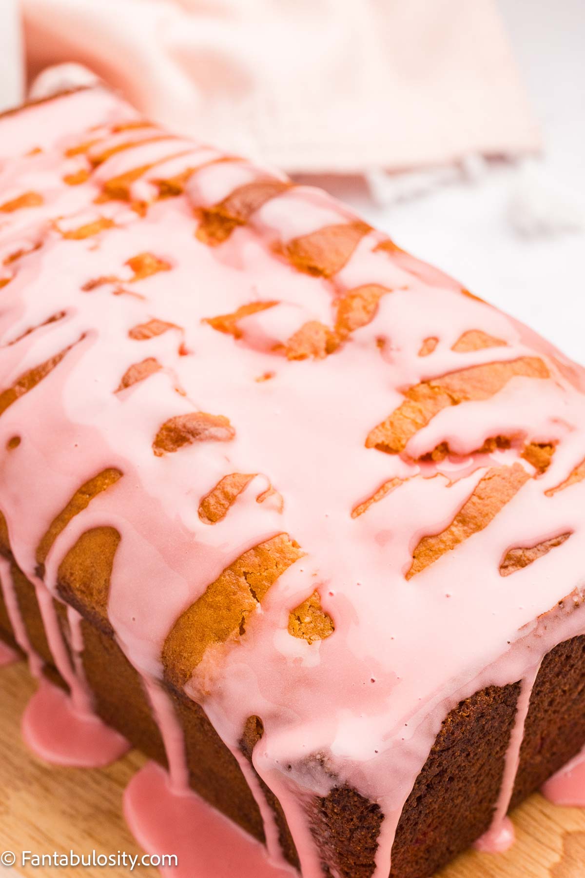 Cherry icing drizzled over the top of cherry bread.
