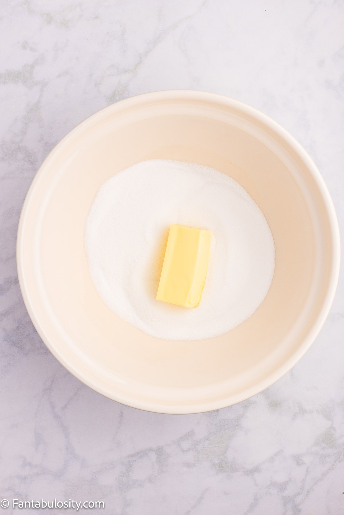 Sugar and butter in mixing bowl.