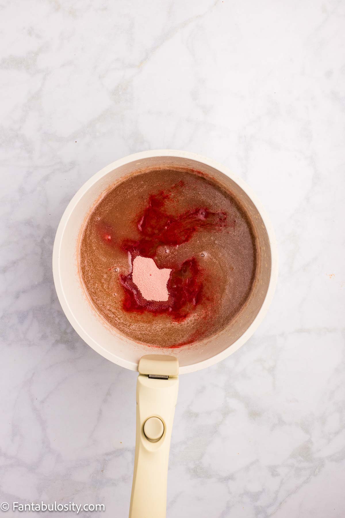 Strawberry frosting ingredients in saucepan.