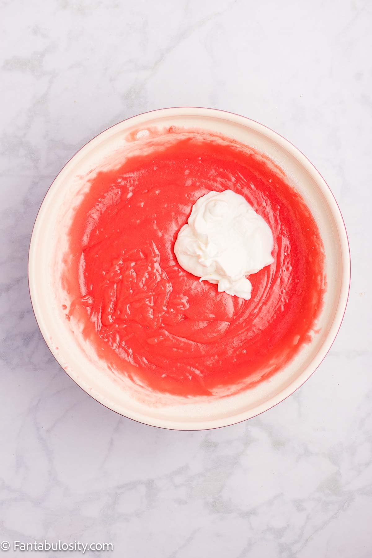 Greek yogurt added to cake batter in mixing bowl.