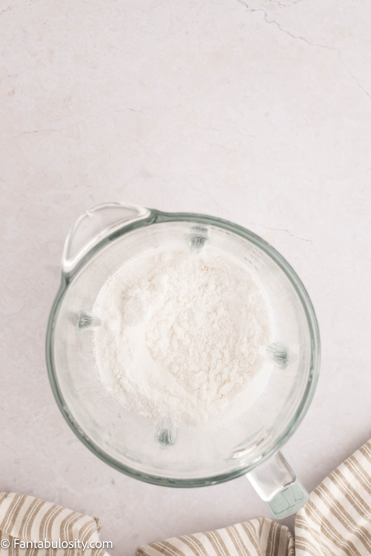 Flour added to processed sugar in mixing bowl.