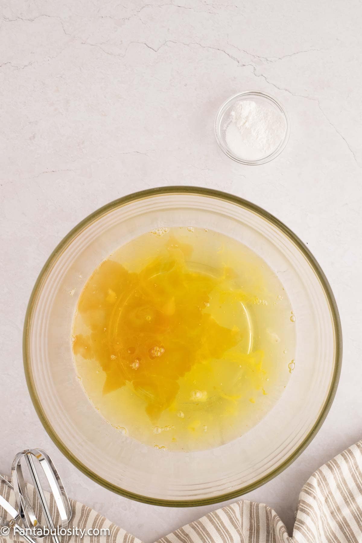 Eggs in mixing bowl with vanilla.
