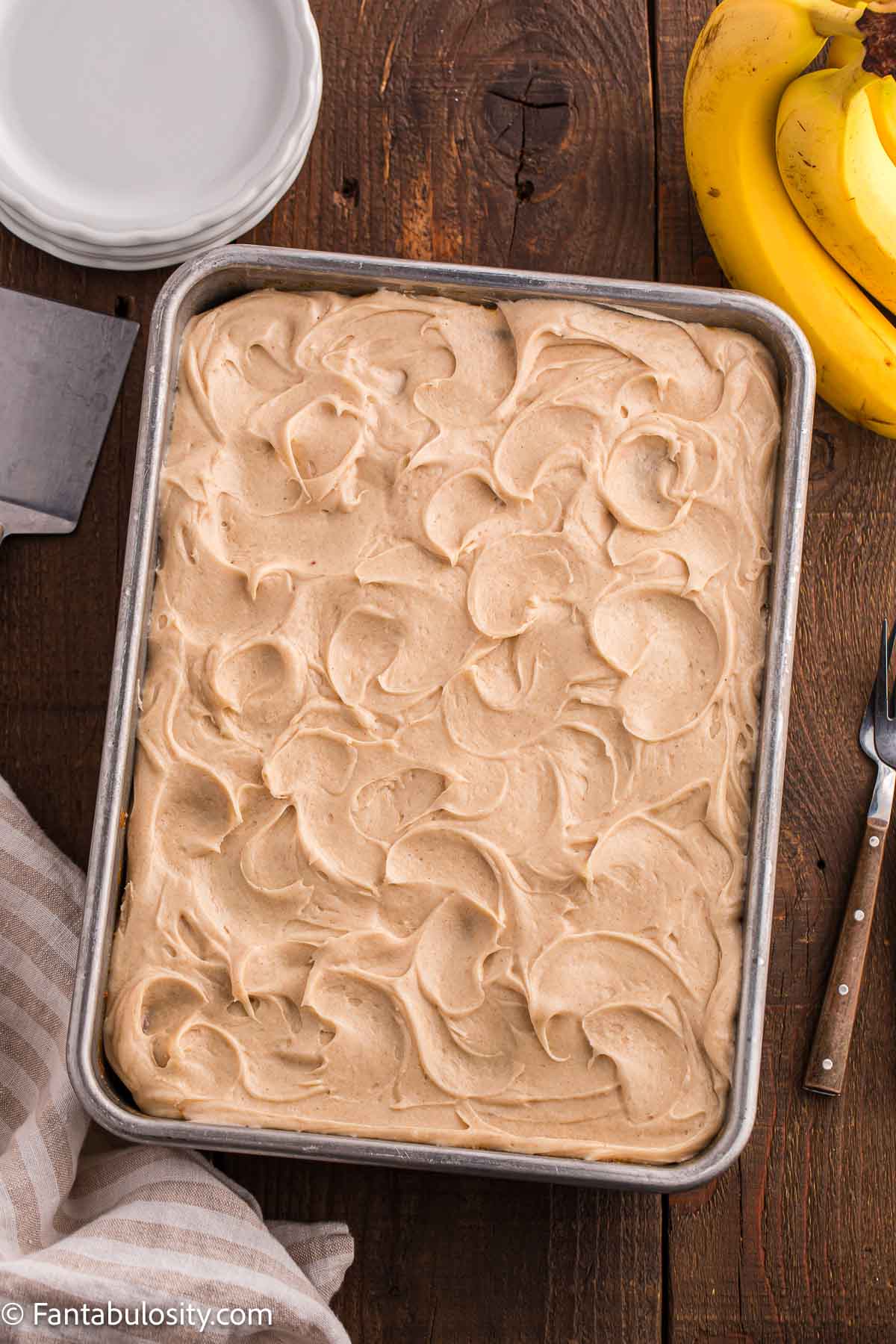 Brown butter frosting spread on top of banana cake.