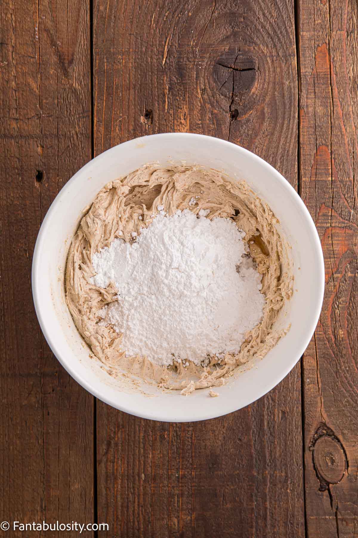 Powdered sugar added to mixing bowl for brown butter frosting.