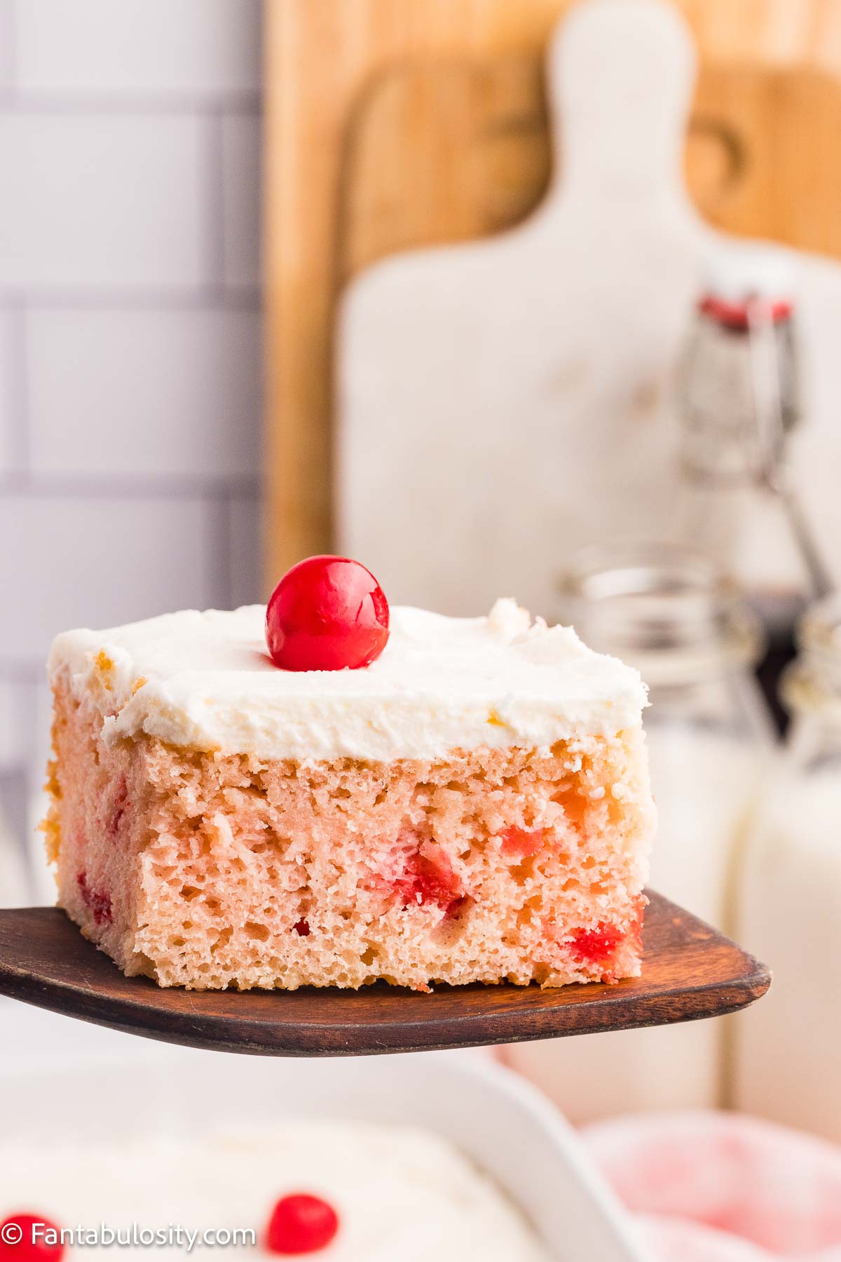 A slice of cherry sheet cake resting on spatula.