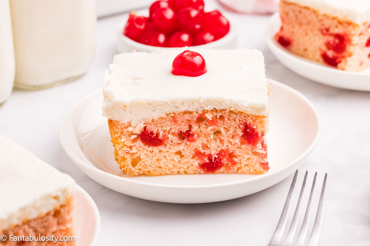 A slice of cherry chip sheet cake on a round plate.