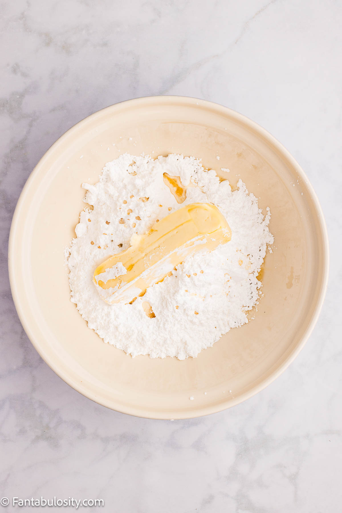 Powdered sugar and butter in mixing bowl.